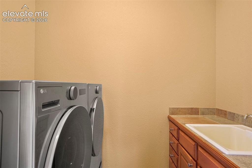 Image 23 of 36: Main level laundry with high-end washer/dryer included, plus utility sink
