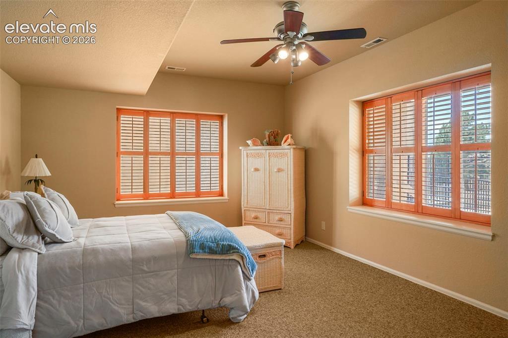Image 29 of 36: Bedroom #3 (non-conforming) with garden level windows and ceiling fan