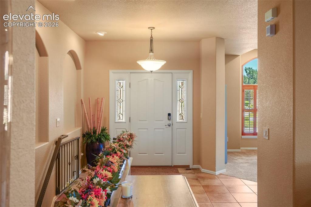 Image 3 of 36: Spacious entry with tile floor, side-light windows and coat closet