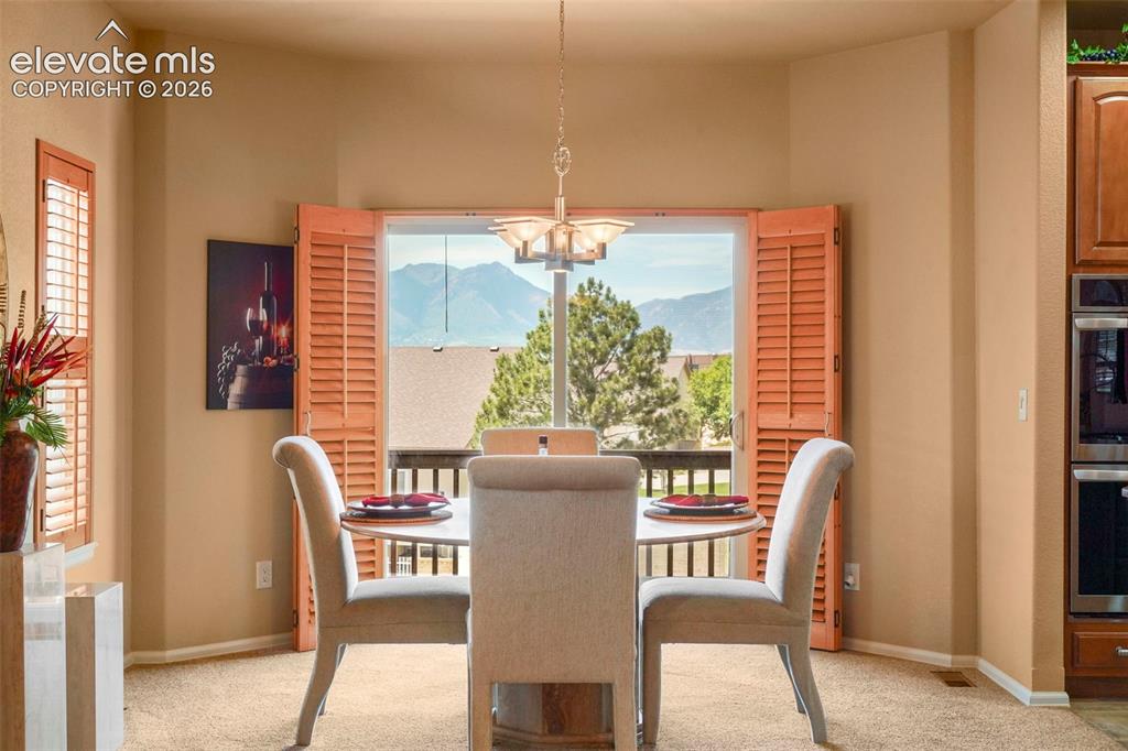 Image 8 of 36: Dining Area with mountain views and walkout to deck