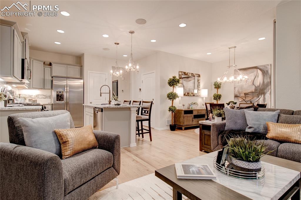Image 12 of 28: Living room with a chandelier, light wood-type flooring, and recessed light
