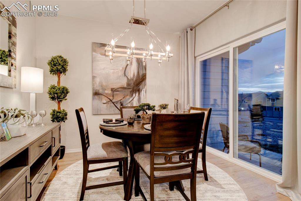 Image 13 of 28: Dining area with light wood finished floors and a chandelier