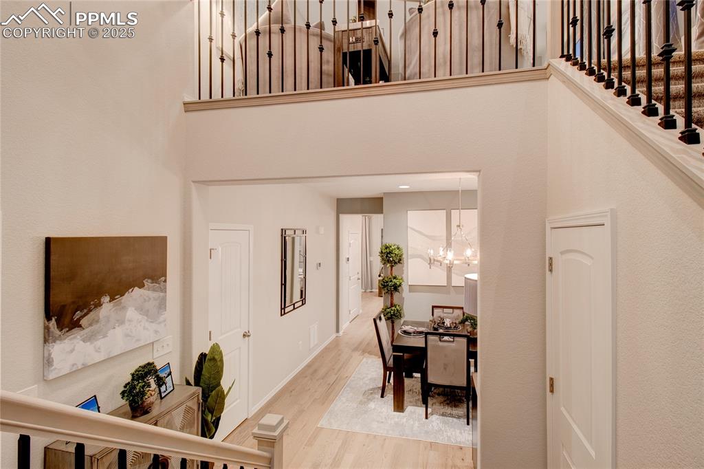 Image 15 of 28: Foyer with wood finished floors and a chandelier