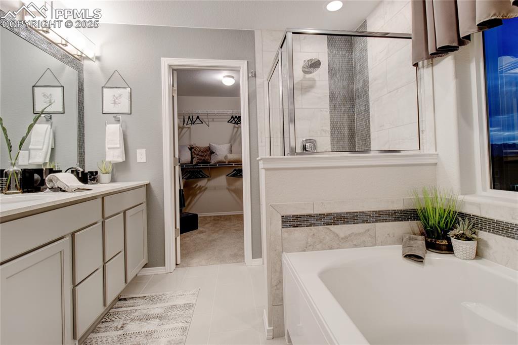Image 20 of 28: Full bathroom with a shower stall, vanity, a bath, light tile patterned flo