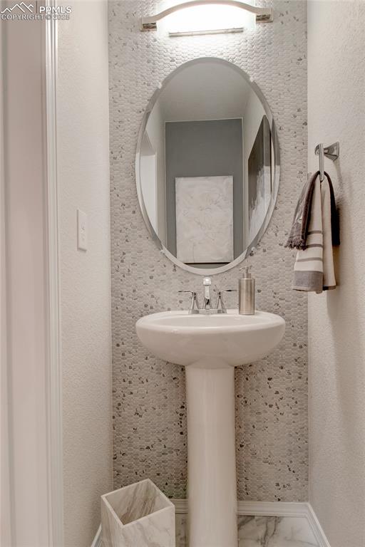 Image 3 of 28: Half bath featuring a textured wall and baseboards