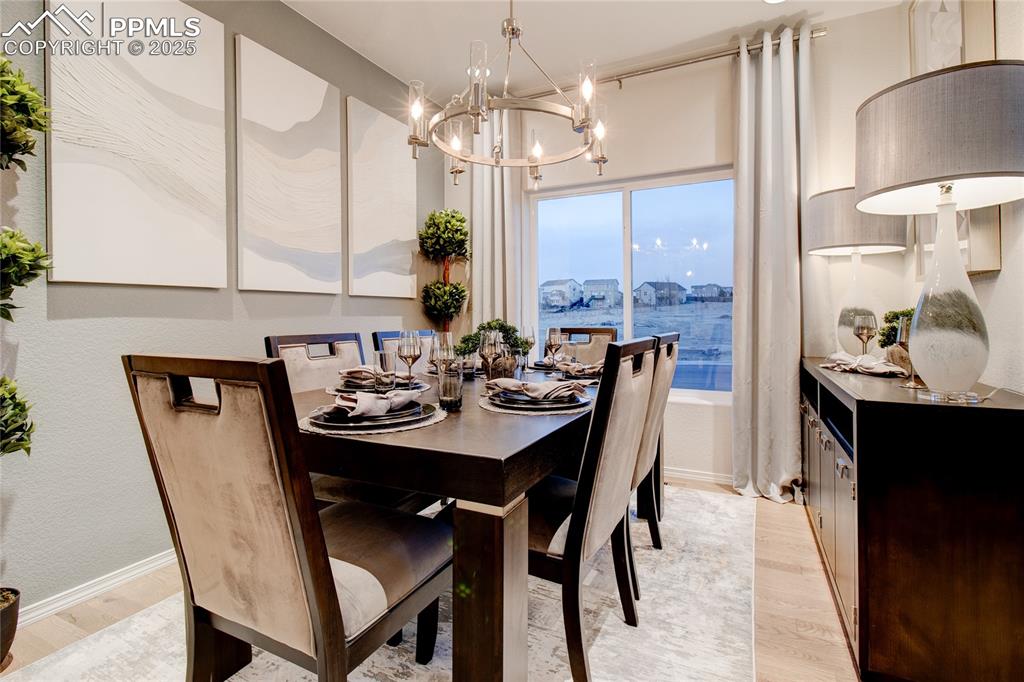 Image 4 of 28: Dining area with light wood finished floors and a chandelier