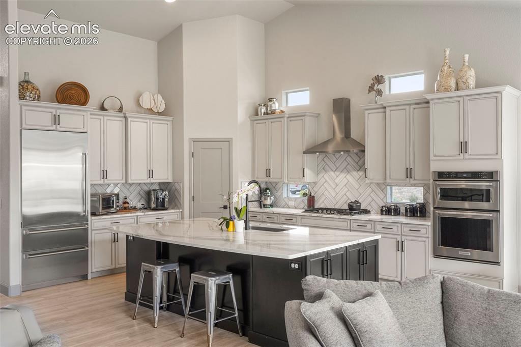 Image 10 of 31: Open-concept kitchen featuring an oversized island with a stone countertop,