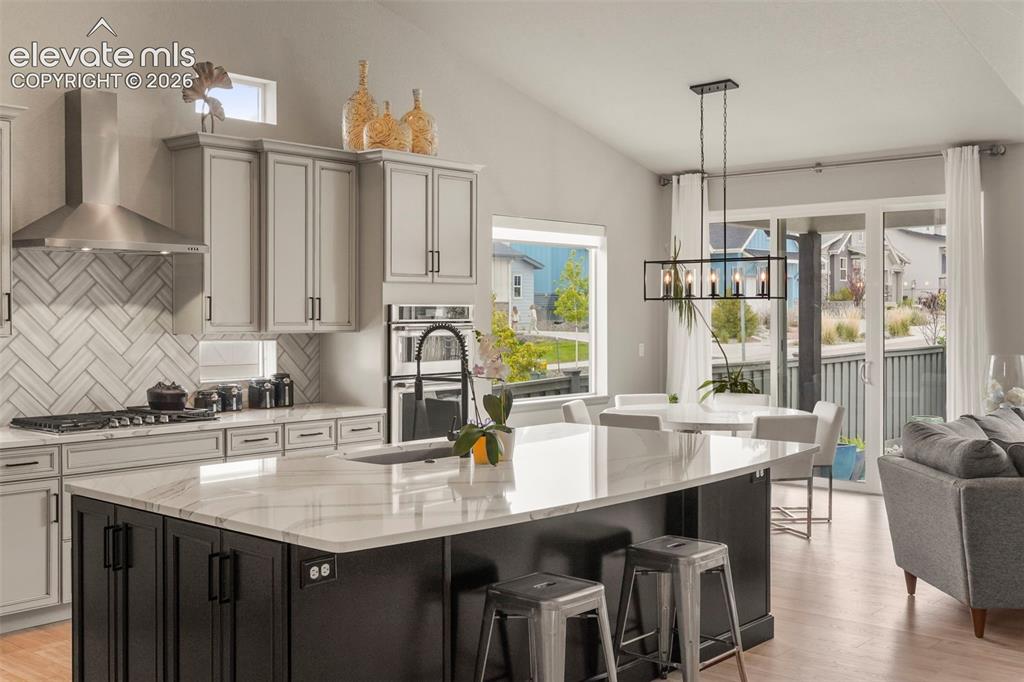 Image 11 of 31: Modern kitchen featuring a large island with a light-toned countertop, cont