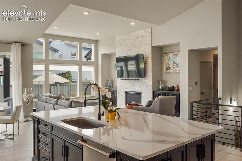 Image 12 of 31: Kitchen island with a light-toned countertop, integrated sink, and dark woo
