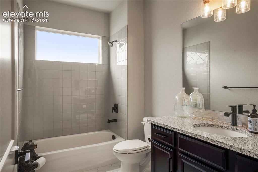 Image 14 of 31: Bathroom featuring a tub/shower combination with subway tile surround, an e