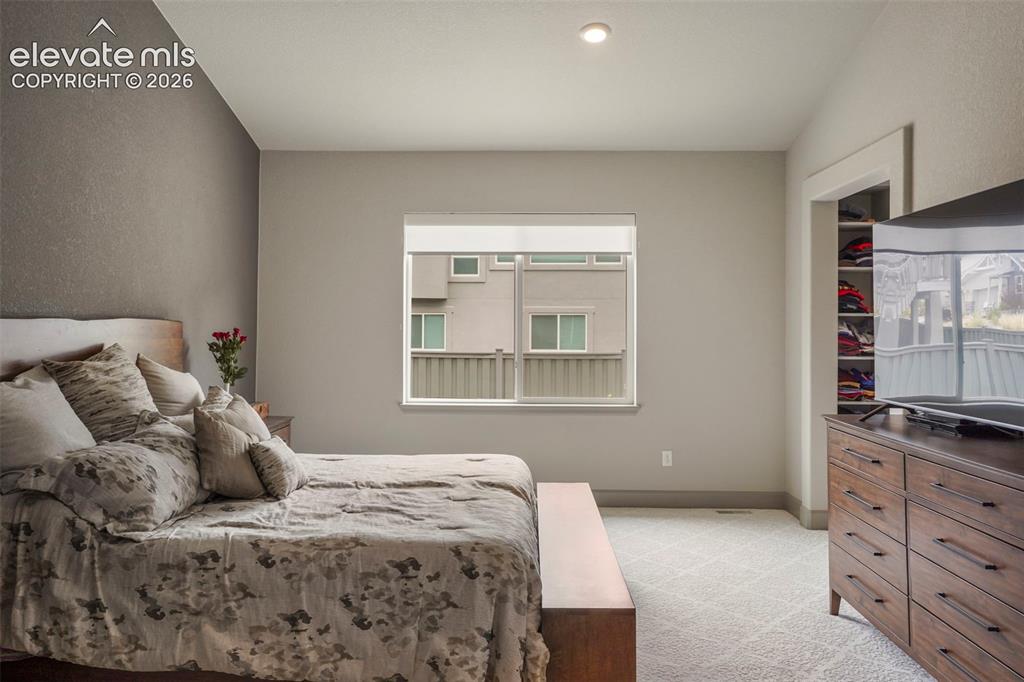 Image 16 of 31: Carpeted room with a textured accent wall, recessed lighting, and a double-