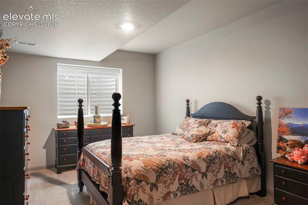Image 26 of 31: Carpeted bedroom featuring neutral wall tones and a window with blinds