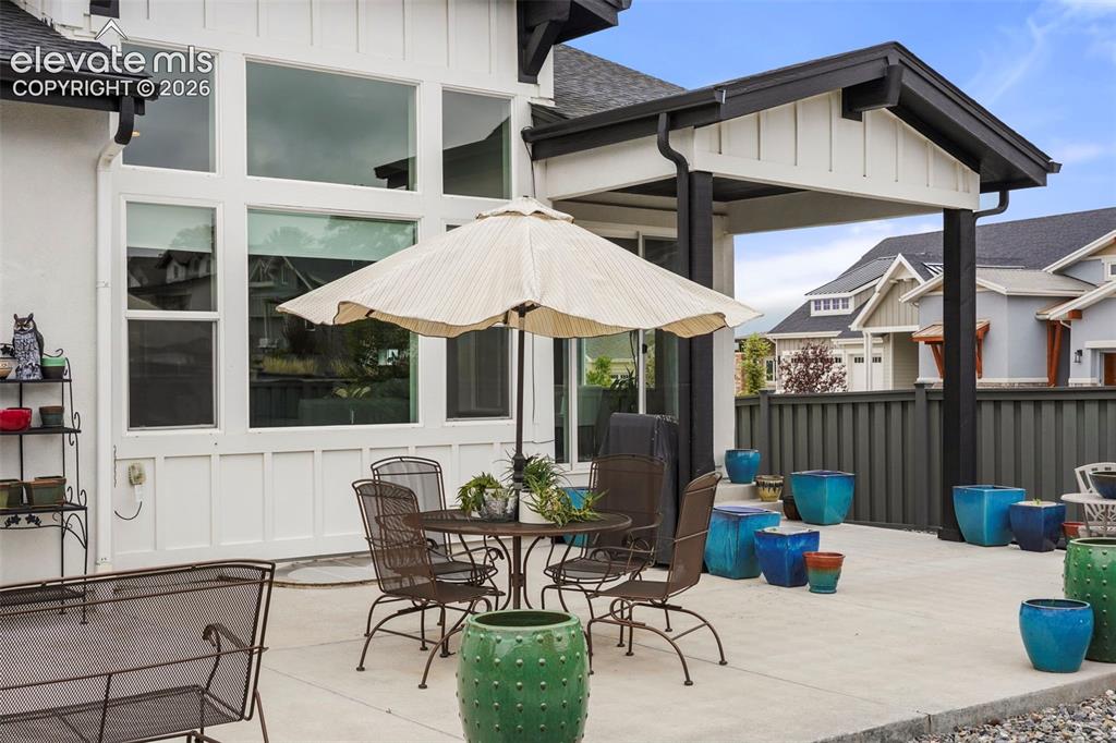 Image 30 of 31: Spacious concrete patio featuring a covered outdoor area, expansive window