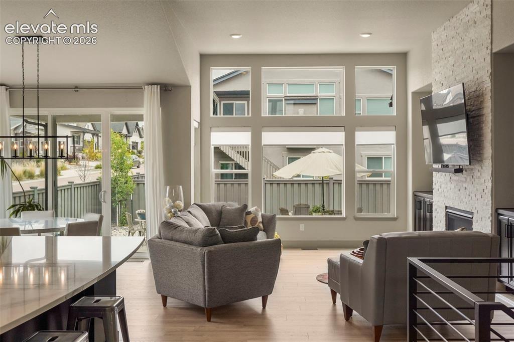 Image 5 of 31: Open-concept living space featuring high ceilings, wood-finish flooring, a