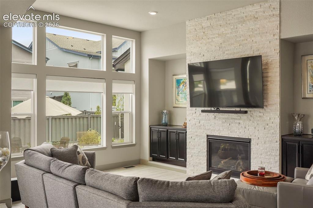 Image 6 of 31: Living area featuring a floor-to-ceiling accent wall with stacked stone, an