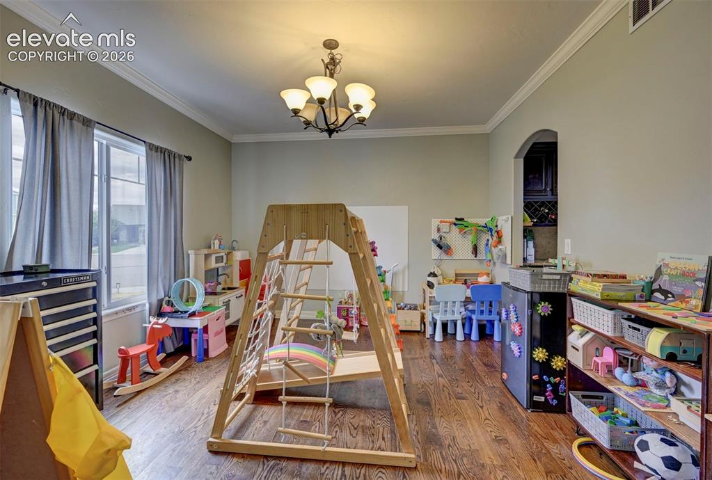 Image 16 of 49: Formal dining room with hardwood floors and crown molding