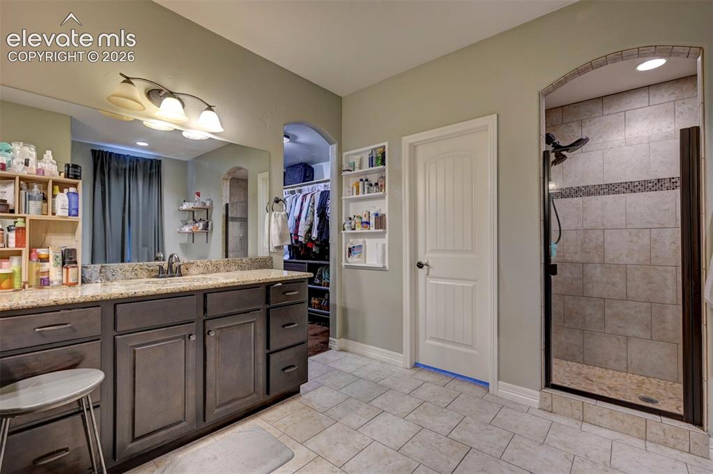 Image 28 of 49: 5-piece primary bath with double vanity and walk-in closet