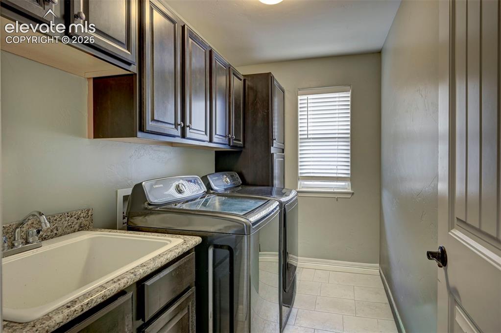 Image 36 of 49: Upstairs laundry room with sink and cabinets