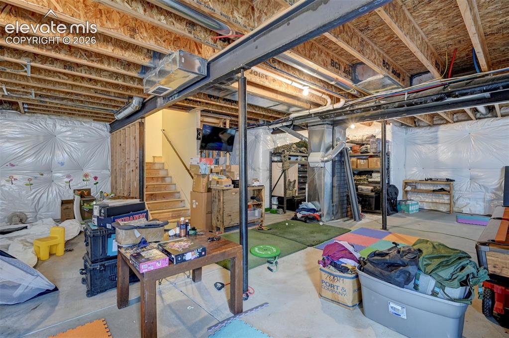 Image 37 of 49: Unfinished basement with egress windows and plumbing rough-in