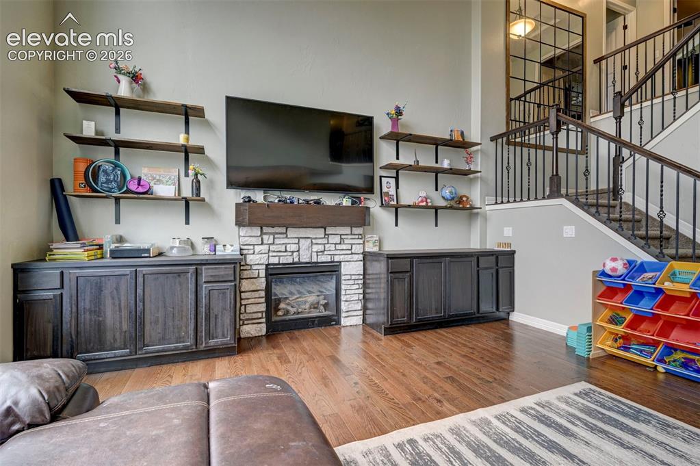 Image 6 of 49: Great room: hardwood floors, built-in cabinets and shelving