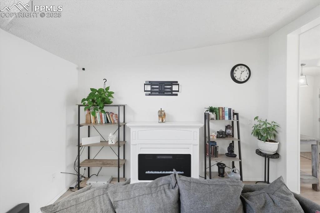 Image 16 of 45: Living area with a fireplace and wood finished floors