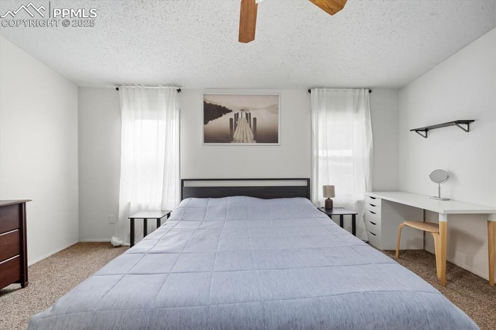 Image 23 of 45: Bedroom featuring light carpet, a ceiling fan, and a textured ceiling