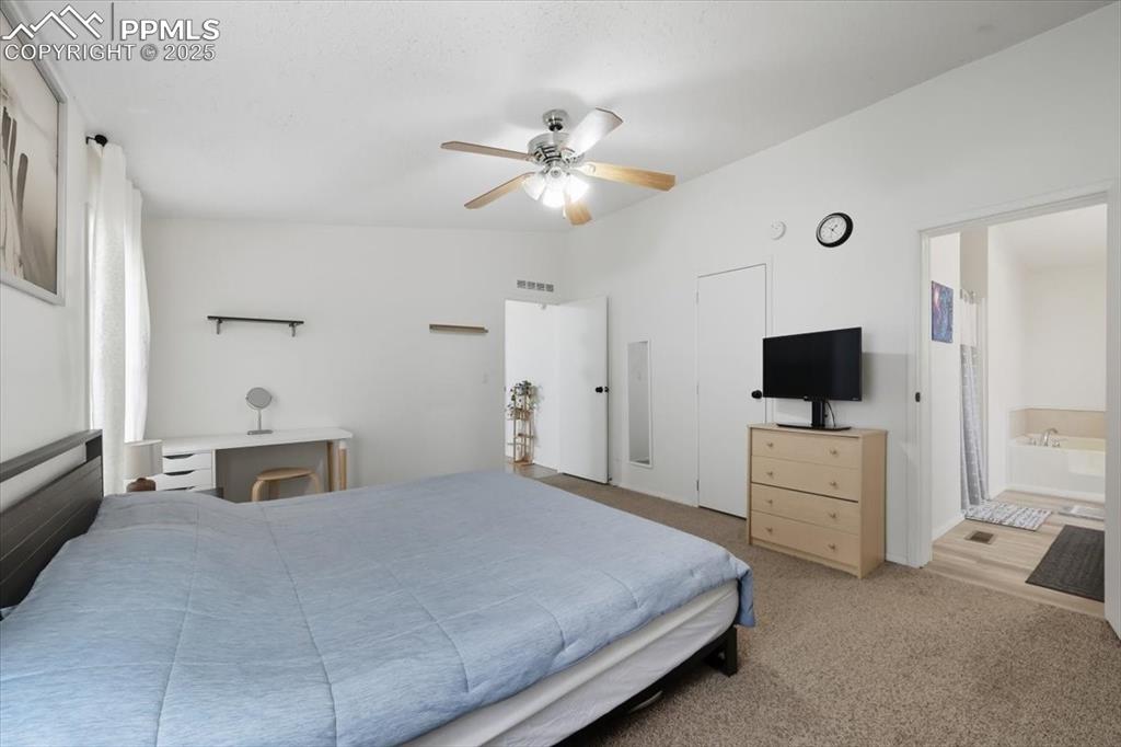 Image 24 of 45: Bedroom featuring carpet floors, ceiling fan, and ensuite bathroom