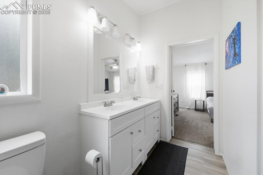 Image 26 of 45: Ensuite bathroom with double vanity and light wood-style flooring