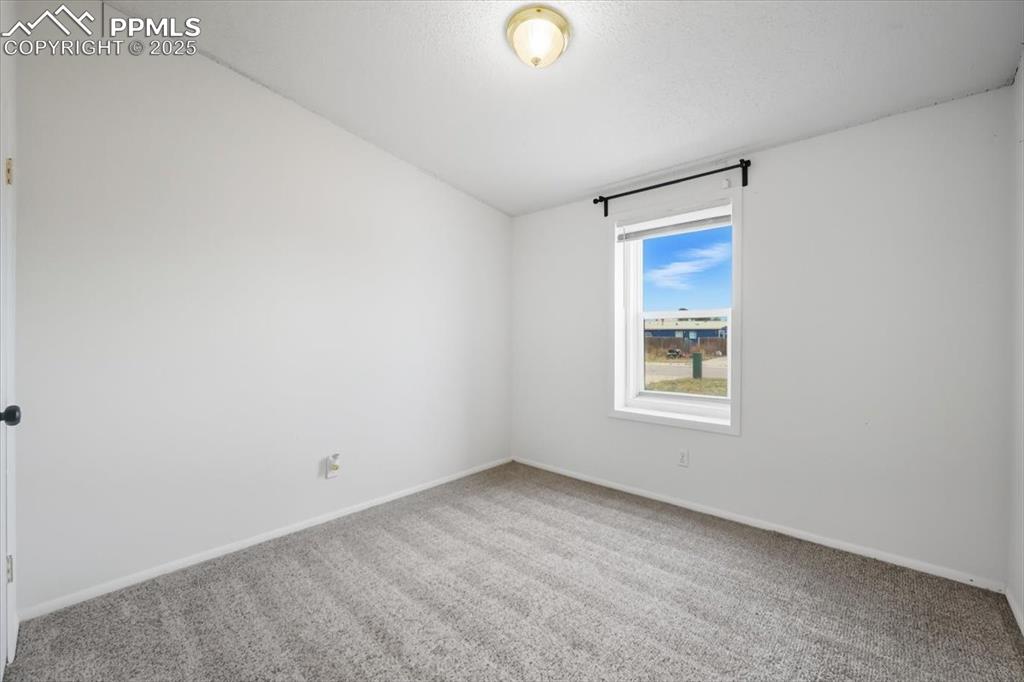 Image 27 of 45: Empty room featuring carpet flooring and baseboards