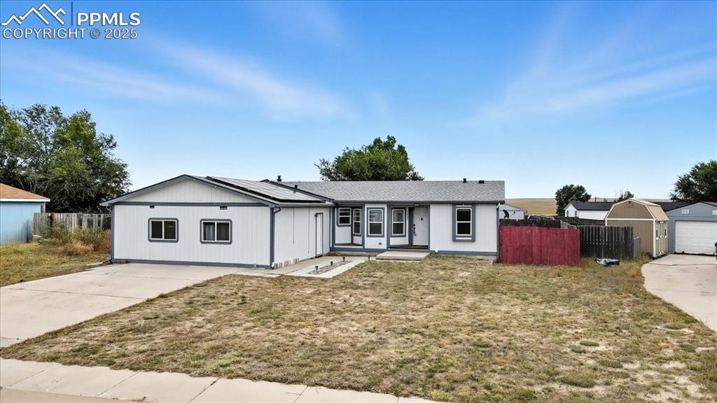 Image 3 of 45: Ranch-style house featuring roof mounted solar panels and driveway