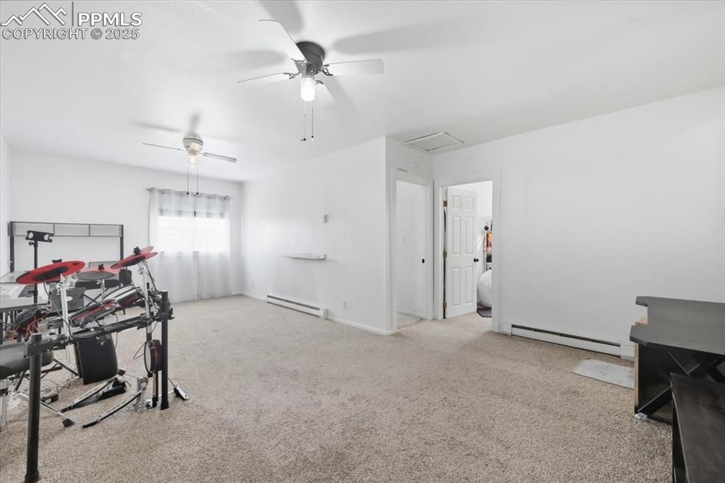 Image 34 of 45: Recreation room featuring a ceiling fan, baseboard heating, light colored c