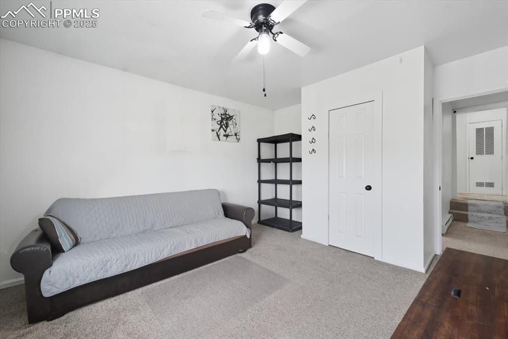 Image 37 of 45: Sitting room with carpet floors, a ceiling fan, and baseboard heating