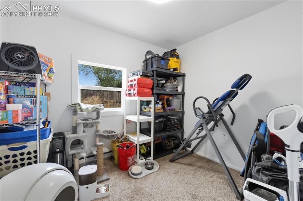Image 38 of 45: Workout area featuring light carpet and baseboards