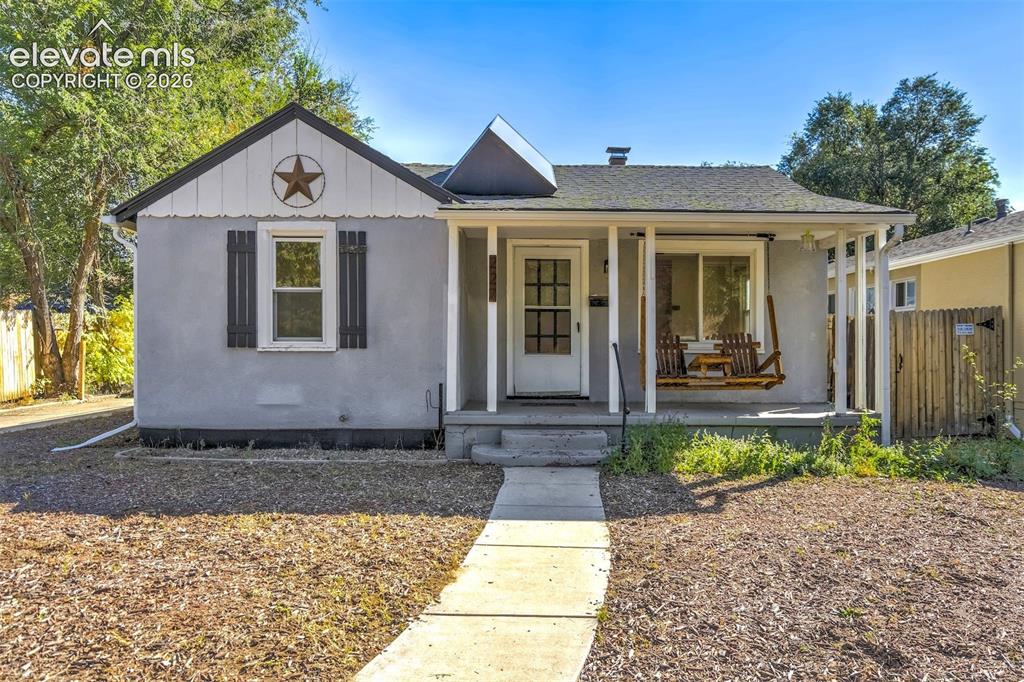 Caption: Single-story exterior featuring a gabled roof, covered front porch with support pillars, and decorat