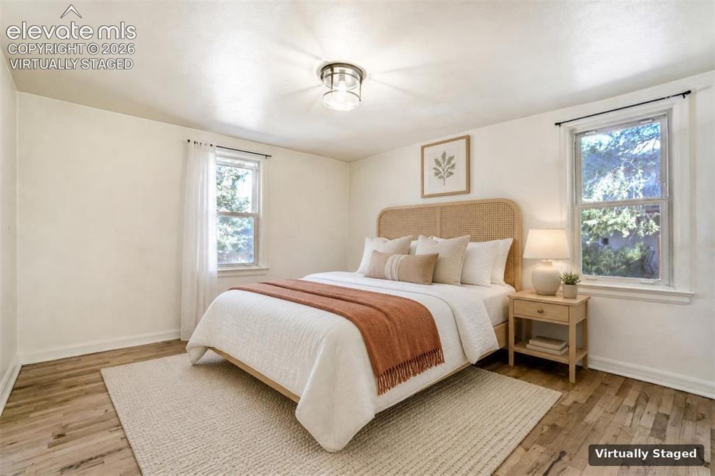 Image 12 of 50: Neutral-toned interior featuring wood-finish flooring, two double-hung wind