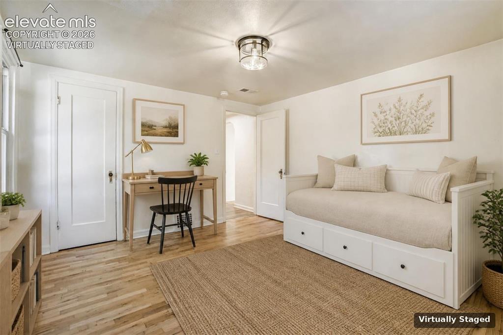Image 16 of 50: Light-filled room featuring wood-finish flooring, crisp white walls, and a
