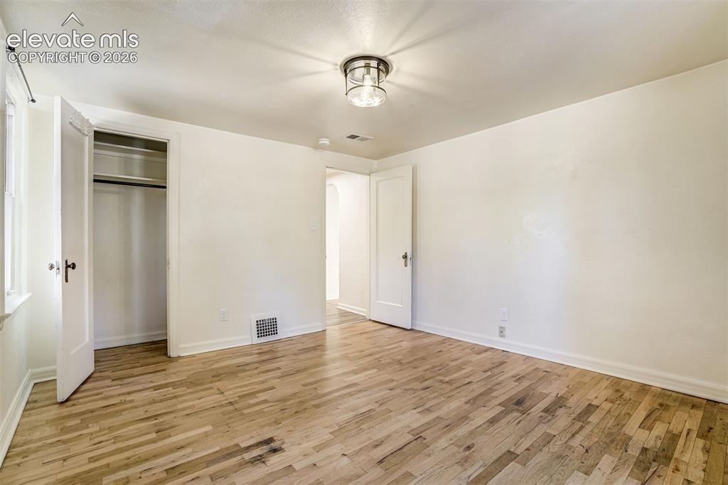 Image 18 of 50: Room featuring wood-finish flooring, a flush-mount drum-style light fixture