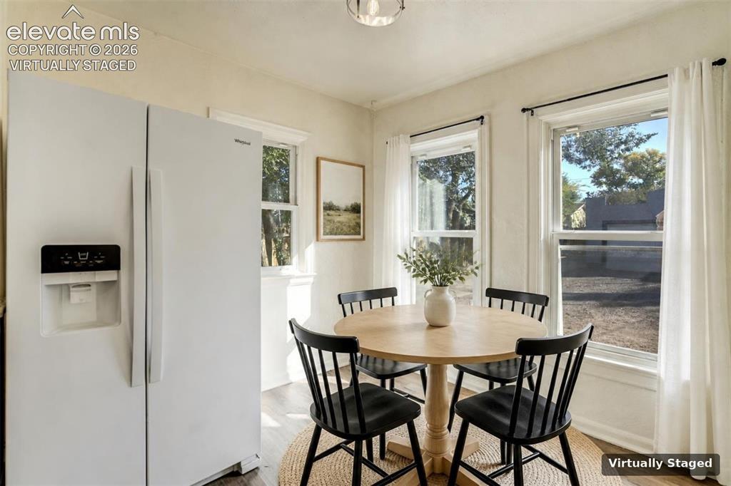 Image 25 of 50: Kitchen area featuring a side-by-side refrigerator, two double-hung windows