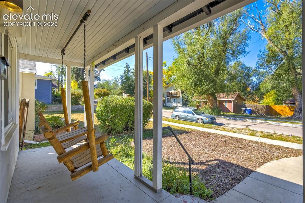 Image 3 of 50: Covered front porch featuring a concrete floor, beadboard ceiling, attached