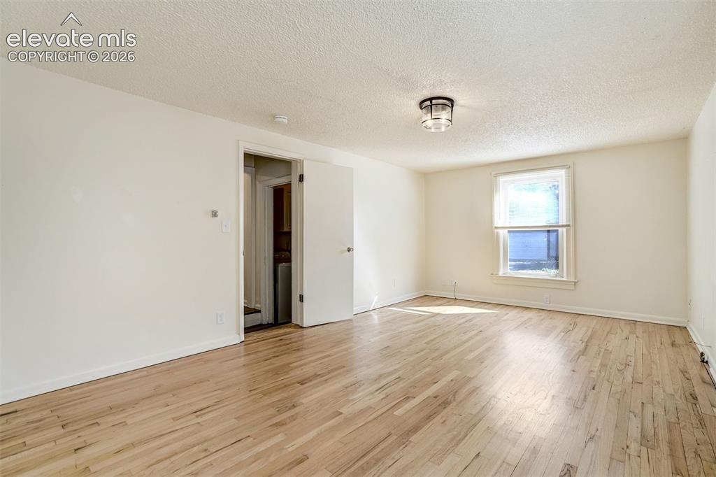 Image 37 of 50: Interior space featuring wood-finish flooring, a single-hung window, and a
