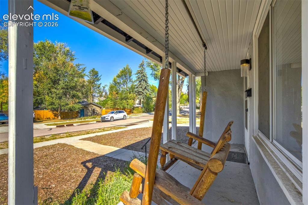 Image 4 of 50: Covered front porch featuring a concrete floor, beadboard ceiling, and wall