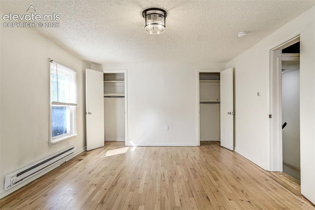 Image 40 of 50: Wood-finish flooring, two reach-in closets with built-in shelving, a multi-