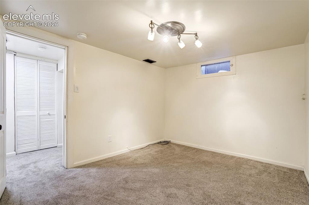 Image 44 of 50: Neutral interior space featuring wall-to-wall carpeting, a multi-light dire