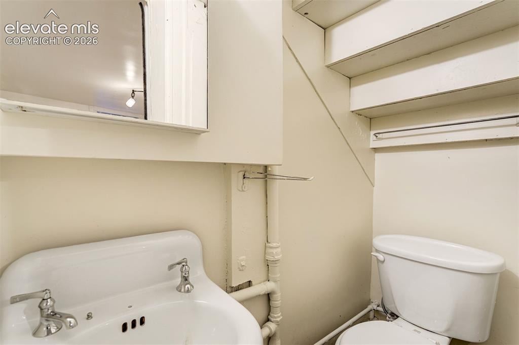 Image 48 of 50: Wall-mounted medicine cabinet with mirror, pedestal sink with dual-handle p
