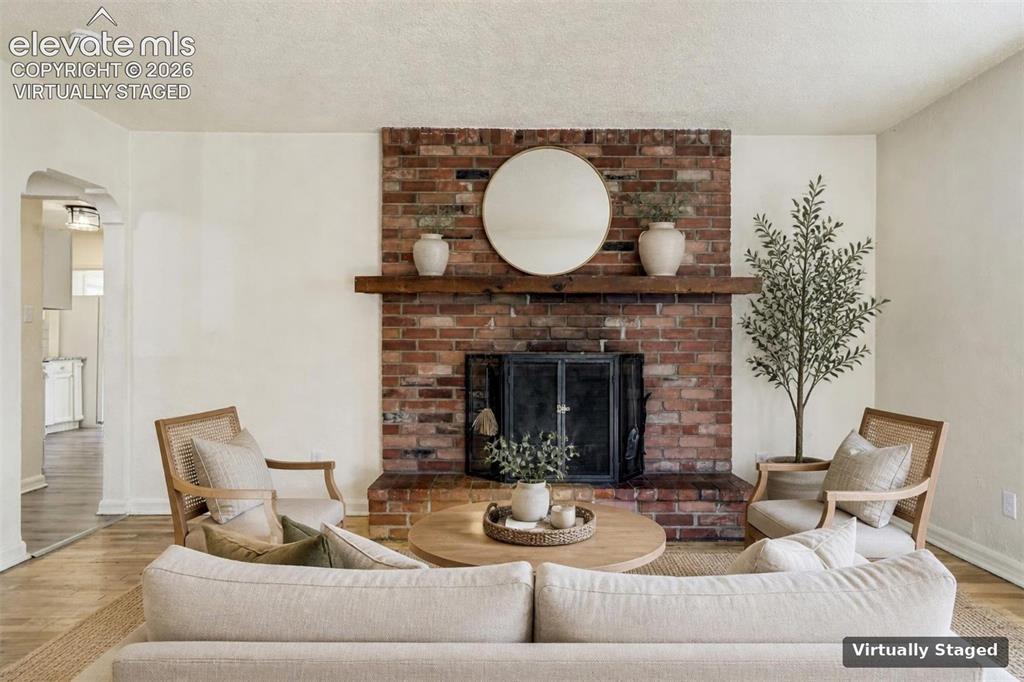Image 5 of 50: Full-height red brick fireplace surround ffeaturing a natural wood mantel,