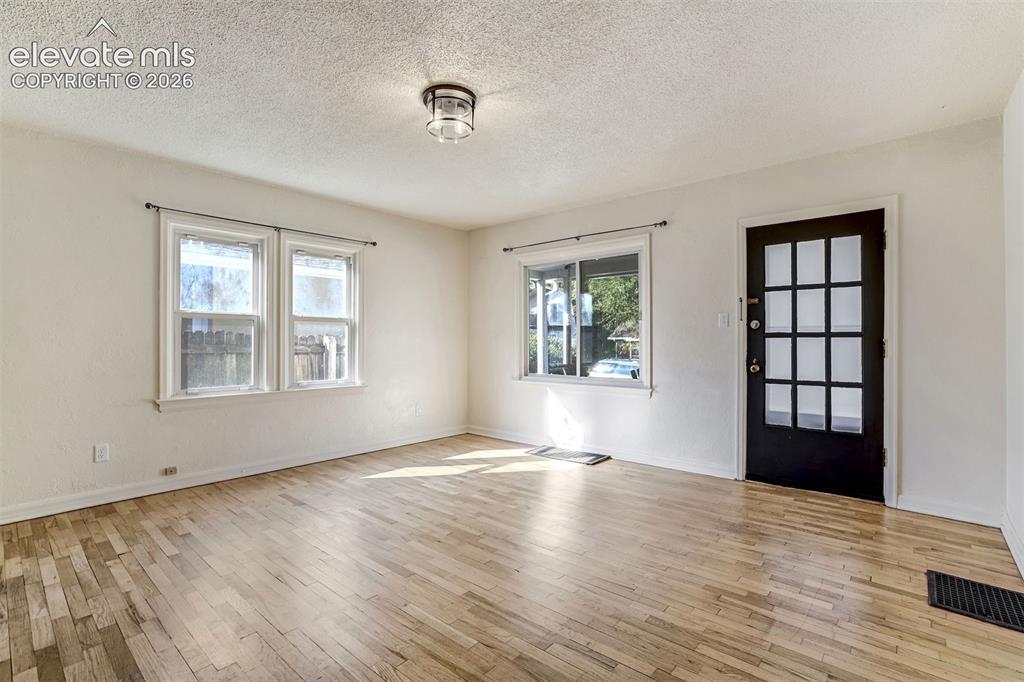 Image 9 of 50: Interior space featuring wood-finish flooring, white walls, multiple window