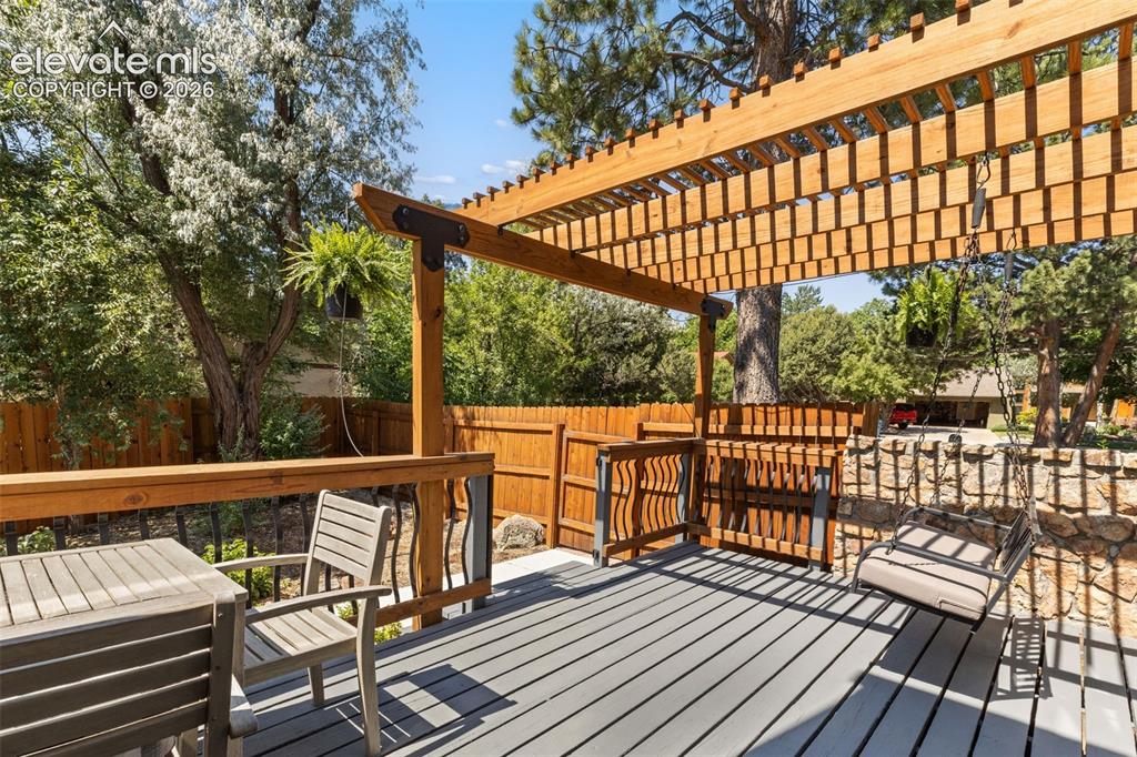 Image 37 of 46: Side yard deck with porch swing.