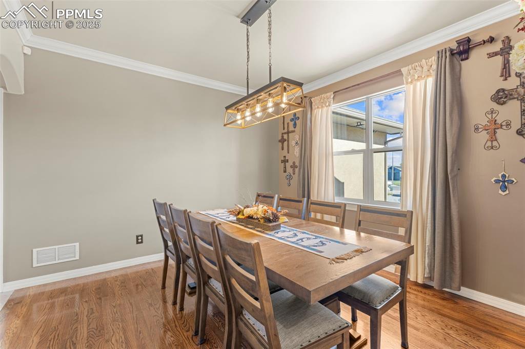 Image 12 of 41: Dining space featuring crown molding and light wood finished floors
