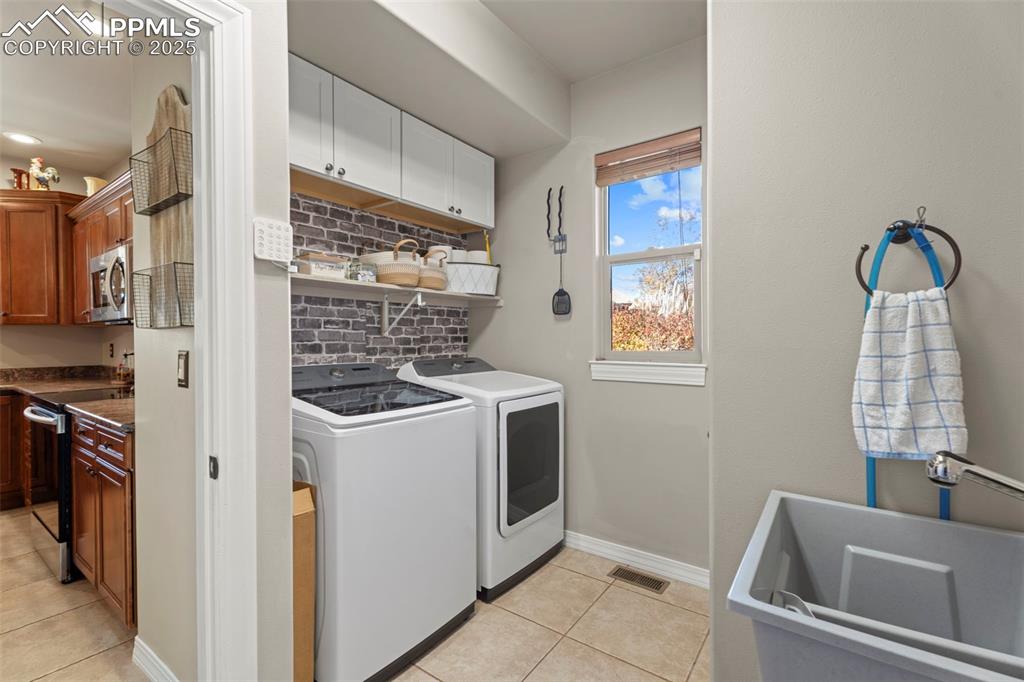 Image 15 of 41: Laundry room featuring light tile patterned flooring, washer and clothes dr