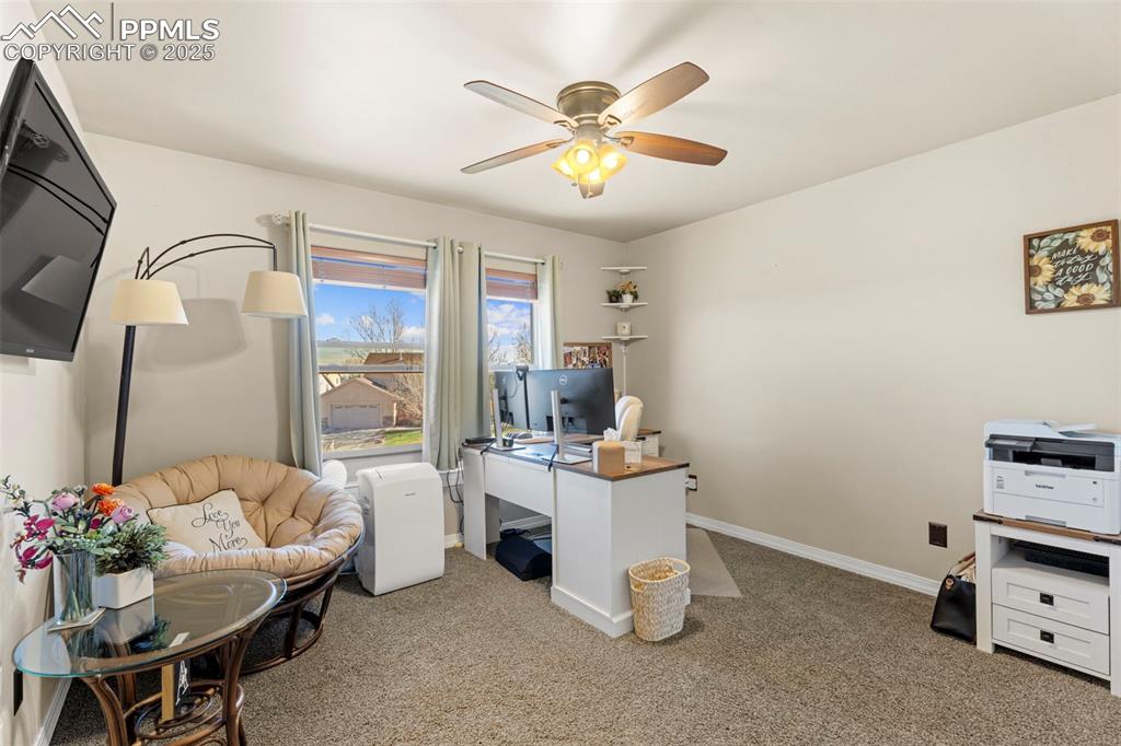 Image 22 of 41: Office area with light carpet and ceiling fan